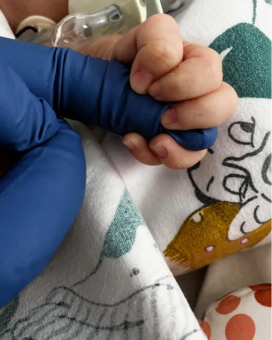 Newborn's hand gripping a gloved finger in the Neonatal Intensive Care Unit in Rome, La Magia di un Sorriso