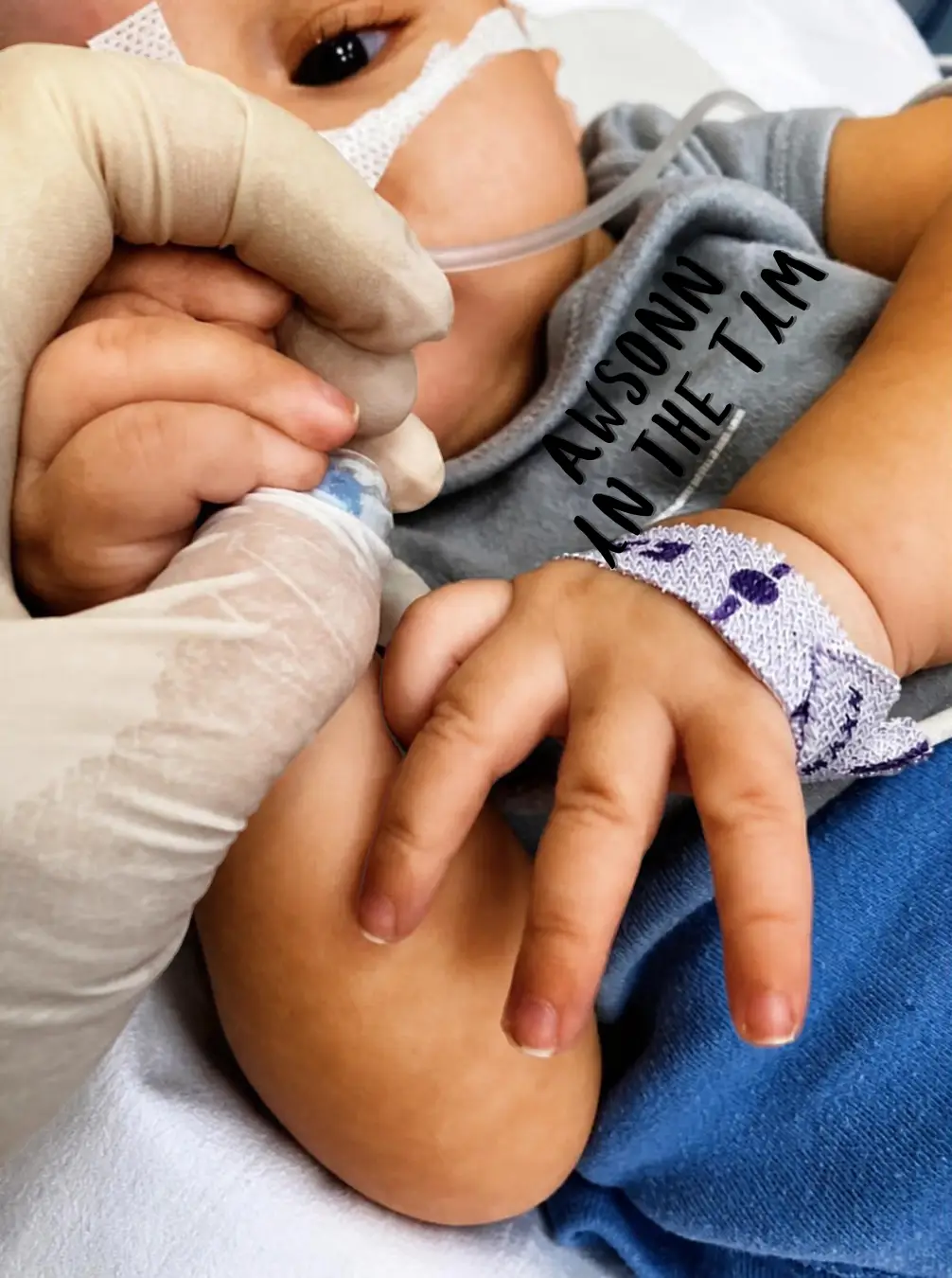 Health worker holding the hand of a young child receiving oxygen in hospital in Rome, La Magia di un Sorriso